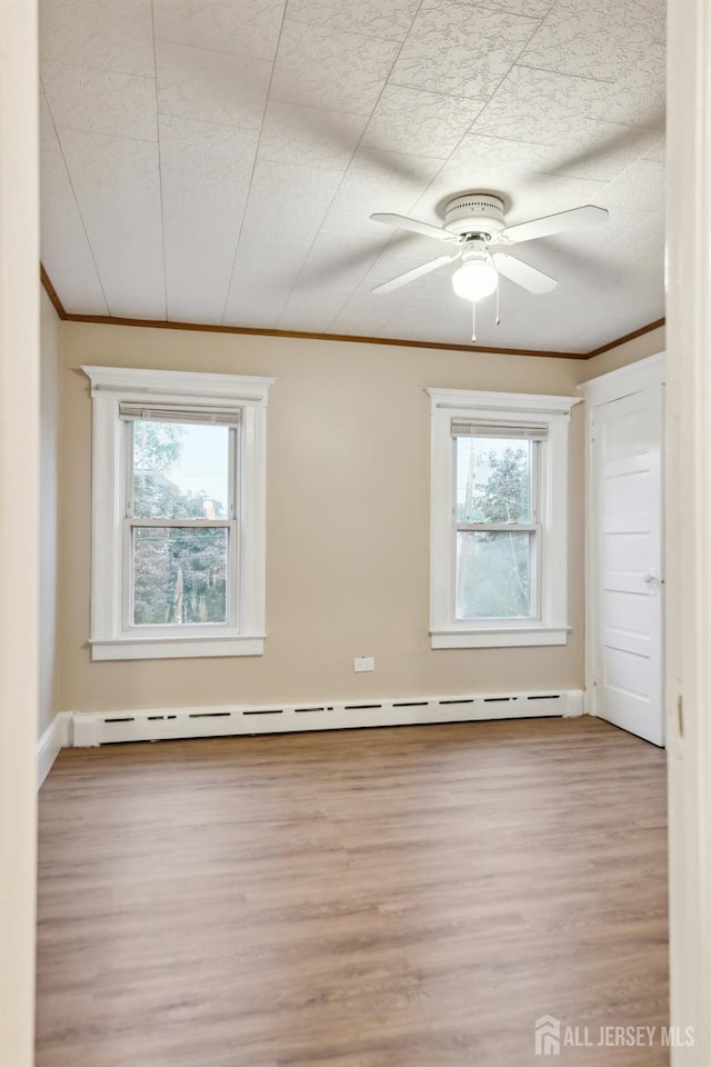 113 Coleman St, Middlesex, NJ 08846 - empty room featuring crown molding, wood finished floors, a baseboard heating unit, and a ceiling fan
