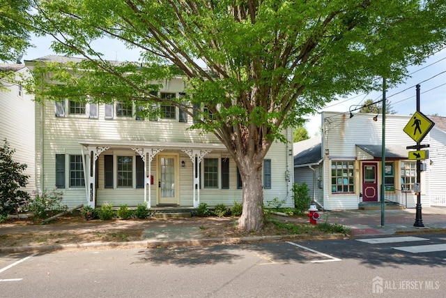 view of front of home with a porch and uncovered parking