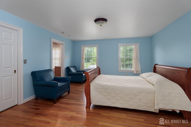 bedroom with baseboards and wood finished floors