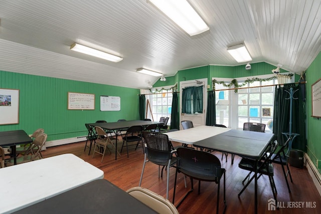 dining area with wood finished floors and vaulted ceiling
