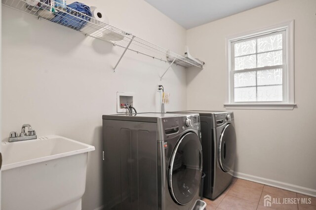 laundry room with sink, light tile patterned floors, and washing machine and clothes dryer