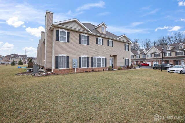 view of front of property featuring central AC unit and a front lawn