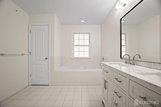 bathroom featuring vanity, tiled bath, and tile patterned flooring