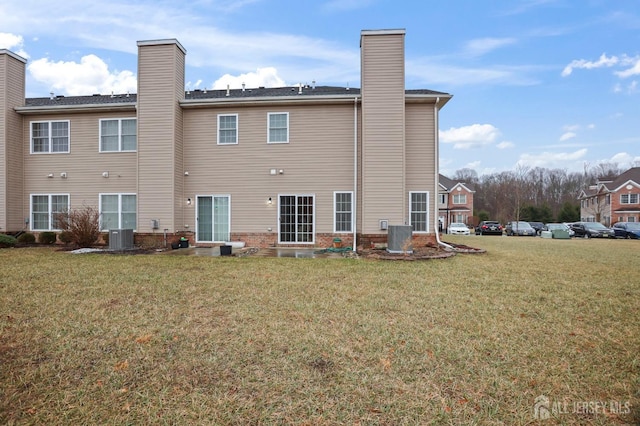 back of house featuring a yard and central air condition unit