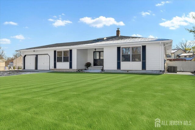 ranch-style house featuring central AC, a garage, and a front lawn