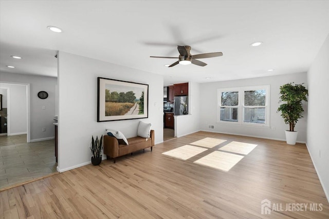 unfurnished living room with ceiling fan and light hardwood / wood-style floors