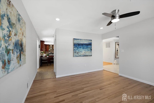 interior space with ceiling fan and light hardwood / wood-style floors