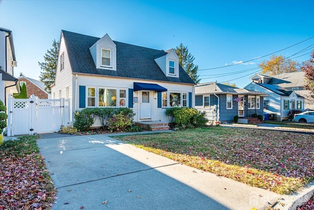 cape cod home featuring a front yard