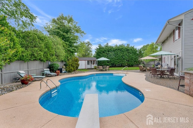 16 Russet Rd, South Brunswick, NJ 08824 - view of swimming pool with outdoor dining area, a diving board, an outdoor structure, and a fenced backyard