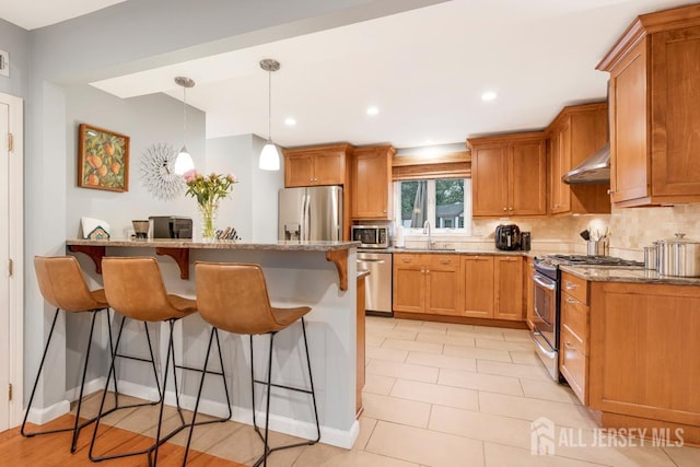 16 Russet Rd, South Brunswick, NJ 08824 - kitchen with appliances with stainless steel finishes, a breakfast bar area, range hood, light stone counters, and tasteful backsplash