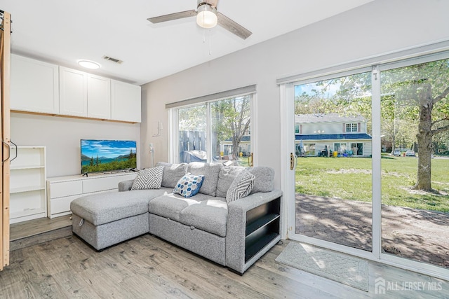 living area with visible vents, a ceiling fan, and light wood-type flooring