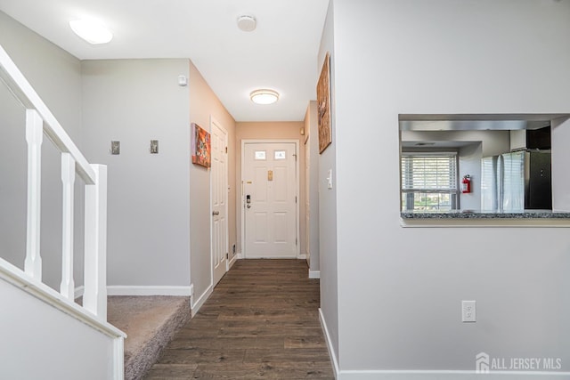hall with baseboards, stairs, and wood finished floors