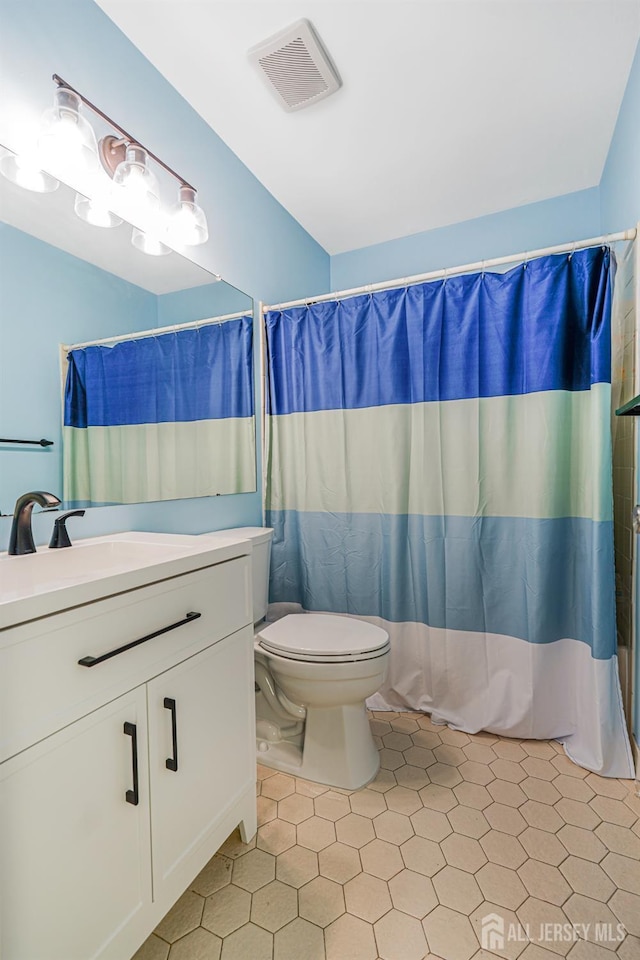 full bath with a shower with curtain, visible vents, tile patterned flooring, vanity, and toilet