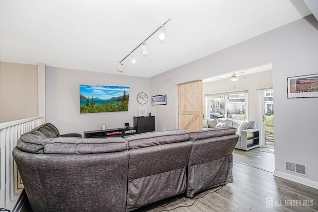 living room with track lighting, a ceiling fan, baseboards, wood finished floors, and visible vents