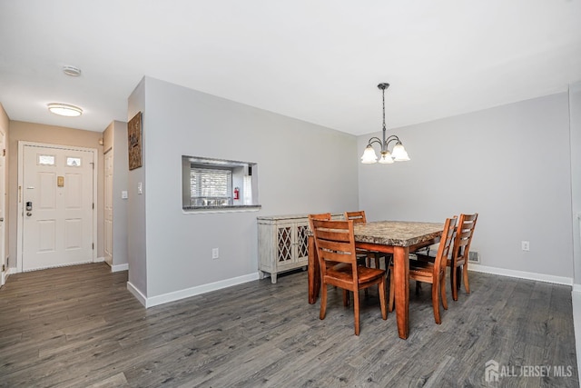 dining room featuring baseboards, wood finished floors, and a chandelier
