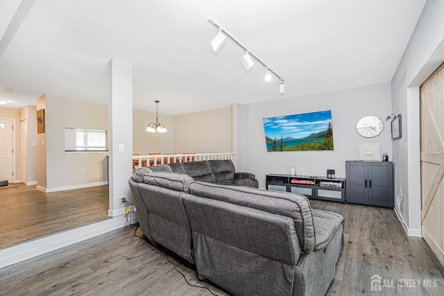 living room featuring baseboards, a chandelier, and wood finished floors