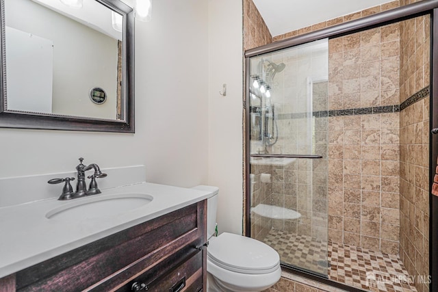 bathroom with vanity, a stall shower, and toilet