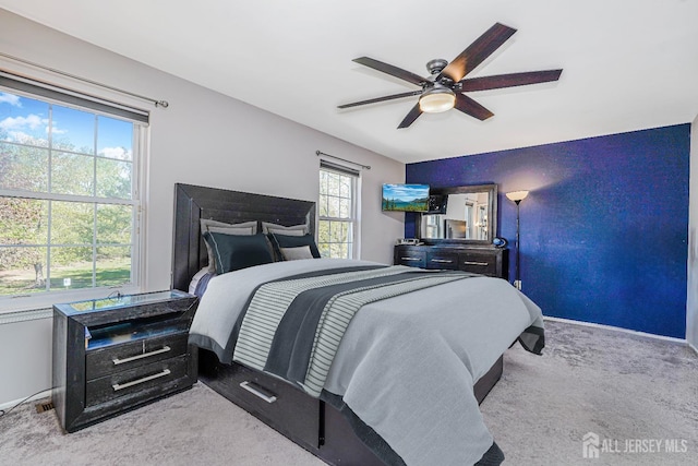 carpeted bedroom featuring baseboards and a ceiling fan