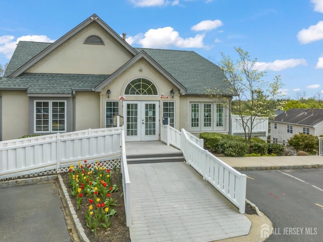 1301 Cypress Ln, East Brunswick, NJ 08816 - view of front of property with french doors, roof with shingles, stucco siding, and uncovered parking
