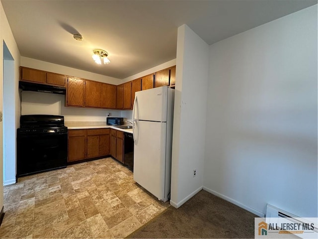 kitchen featuring black appliances, brown cabinetry, light countertops, baseboards, and extractor fan