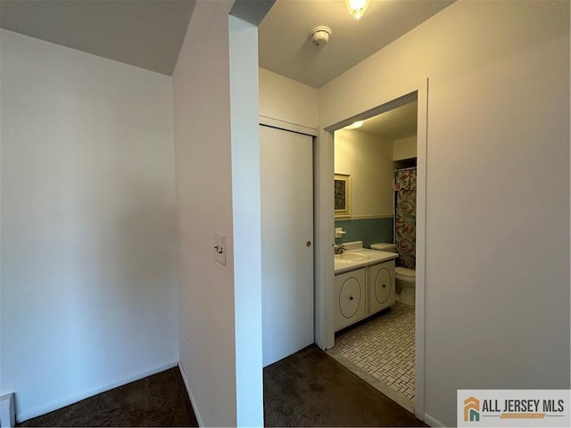 full bath with toilet, vanity, and baseboards