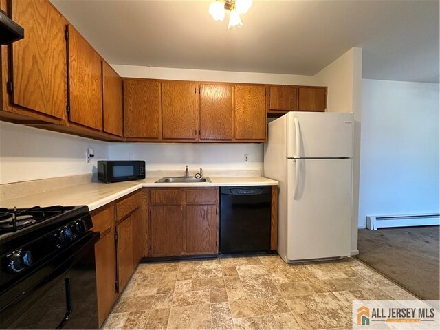 414 Cricket Ln Unit 414, Woodbridge Proper, NJ 07095 - kitchen with black appliances, baseboard heating, brown cabinetry, light countertops, and stone finish floors