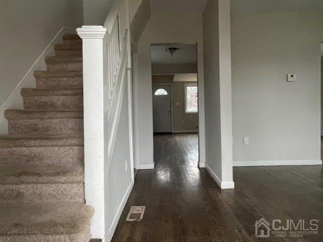 stairway with baseboards and wood finished floors