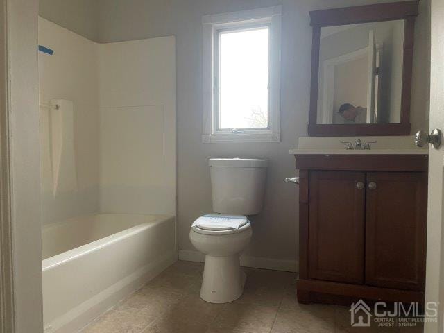 full bathroom with bathtub / shower combination, toilet, vanity, baseboards, and tile patterned floors