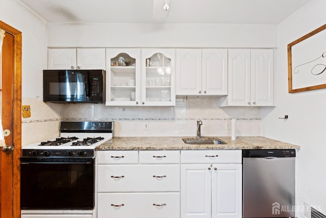 kitchen with a sink, dishwasher, gas stove, black microwave, and white cabinetry