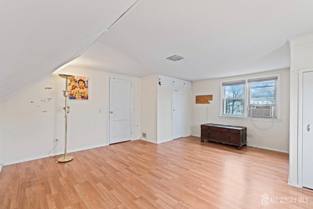 bonus room with light wood-type flooring, baseboards, vaulted ceiling, and cooling unit