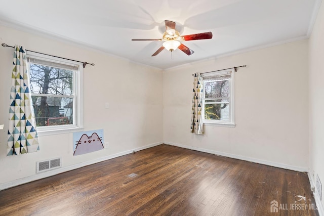 empty room featuring ceiling fan, baseboards, visible vents, and wood finished floors