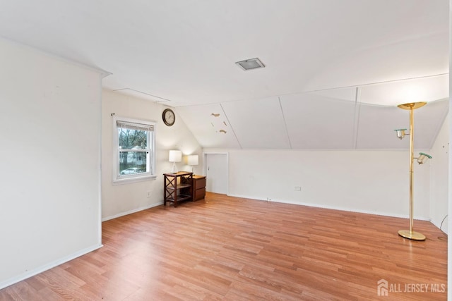 bonus room with light wood finished floors, vaulted ceiling, and baseboards