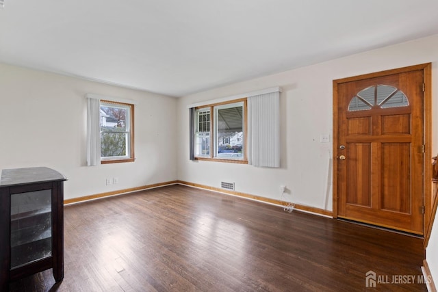 unfurnished living room with dark wood finished floors and baseboards