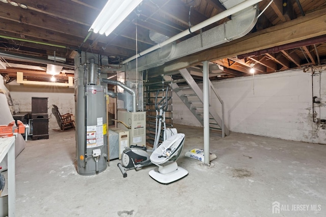 unfinished basement with heating unit, gas water heater, and stairs