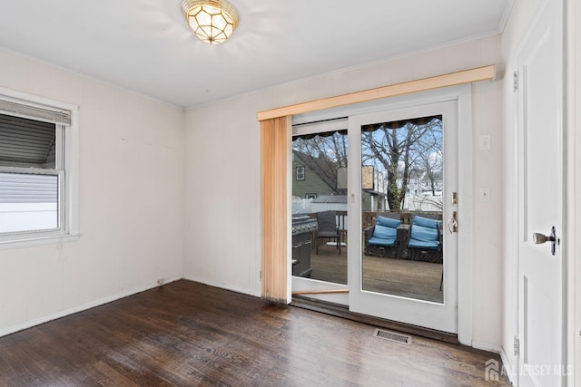 empty room with ornamental molding and dark wood-style flooring