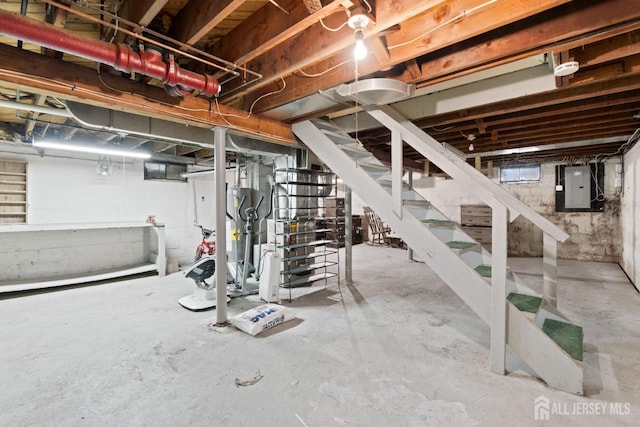unfinished below grade area with electric panel and stairway