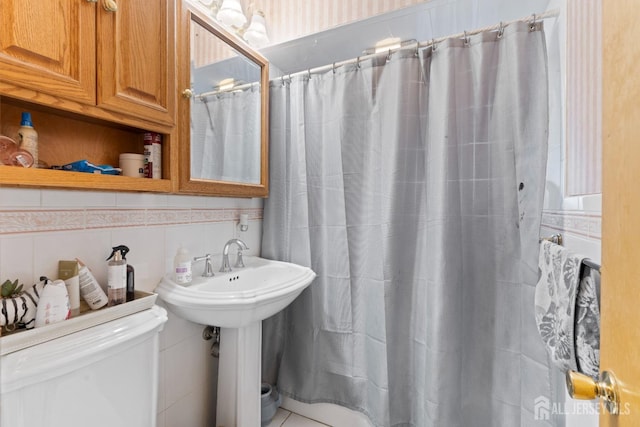 bathroom featuring toilet, curtained shower, tile walls, and decorative backsplash