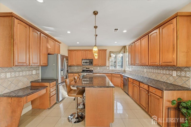 6 Lexington Ct, Monroe, NJ 08831 - kitchen featuring a sink, stainless steel appliances, dark stone countertops, a kitchen bar, and decorative backsplash