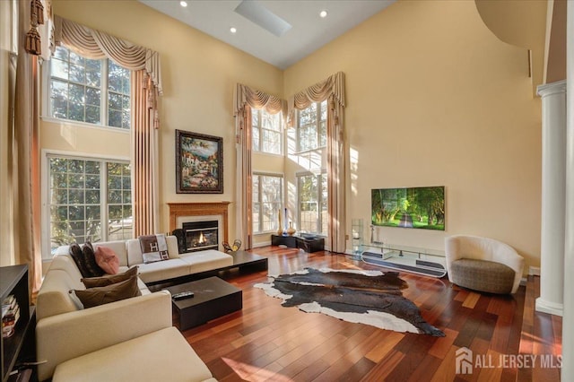 6 Lexington Ct, Monroe, NJ 08831 - sitting room with a towering ceiling, healthy amount of natural light, a glass covered fireplace, hardwood / wood-style floors, and ornate columns
