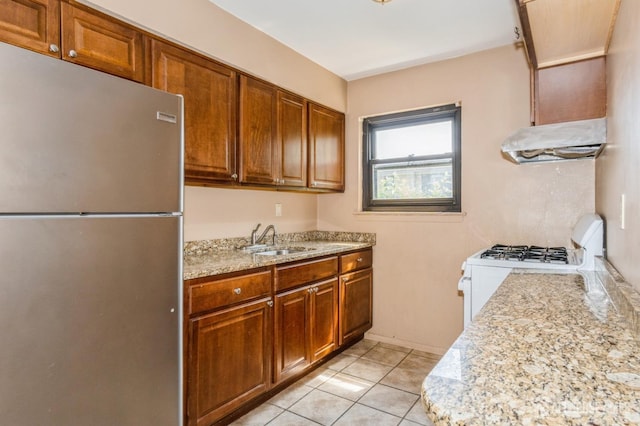 401 US Highway 22nd Rd Unit B8U1, North Plainfield, NJ 07060 - kitchen with freestanding refrigerator, under cabinet range hood, white gas range oven, light tile patterned floors, and brown cabinets