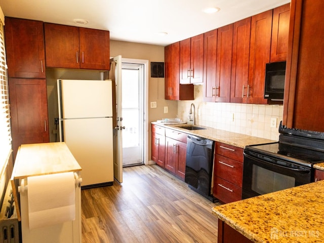 237 Cook Ave, Middlesex, NJ 08846 - kitchen featuring a sink, black appliances, light wood-style flooring, and reddish brown cabinets