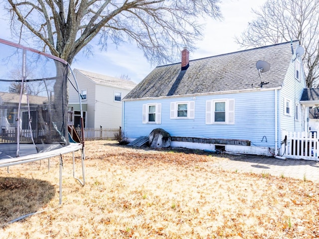 237 Cook Ave, Middlesex, NJ 08846 - back of house with a trampoline, roof with shingles, fence, and a chimney