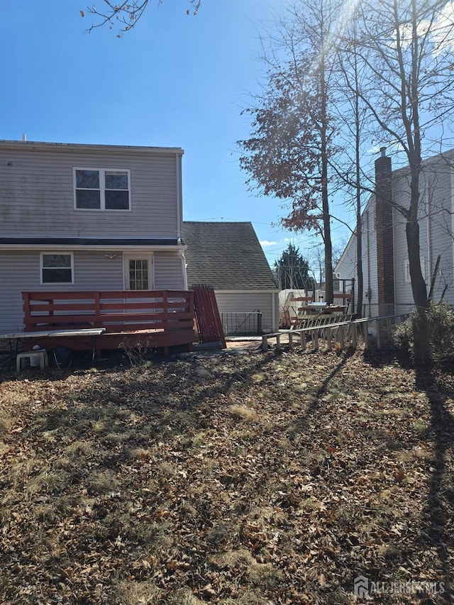 rear view of property with fence and a wooden deck