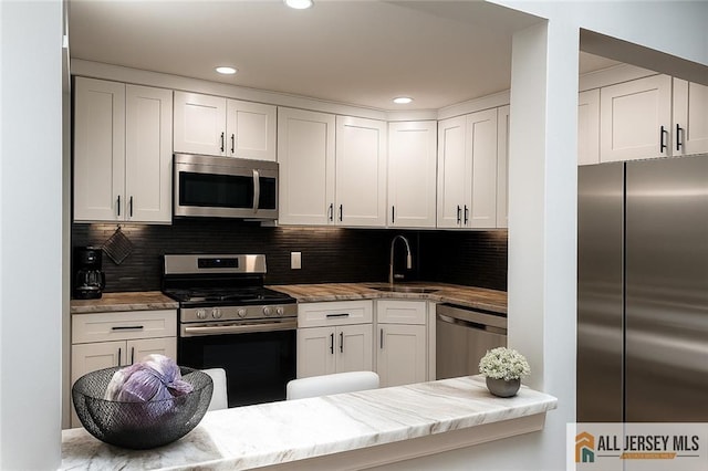 344 Danbury Ln Unit 344, East Brunswick, NJ 08816 - kitchen featuring stainless steel appliances, white cabinets, decorative backsplash, light stone countertops, and recessed lighting