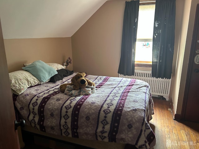 88 Lowell St Unit B, Carteret, NJ 07008 - bedroom with radiator heating unit, vaulted ceiling, and hardwood / wood-style flooring