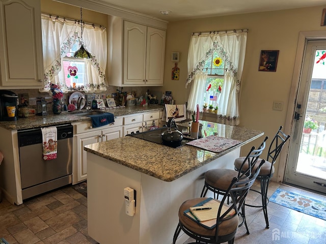 88 Lowell St Unit B, Carteret, NJ 07008 - kitchen with dishwasher, a kitchen breakfast bar, a kitchen island, light stone countertops, and cooktop