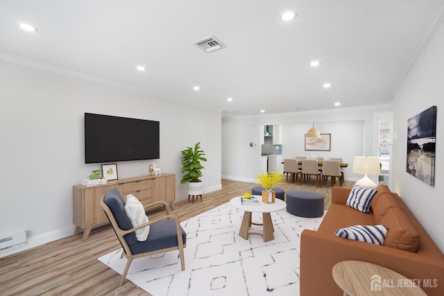 living room with light hardwood / wood-style floors, a baseboard radiator, and ornamental molding