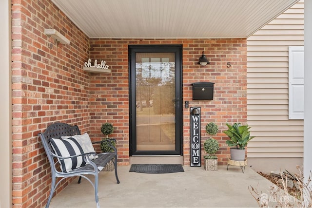 doorway to property featuring brick siding