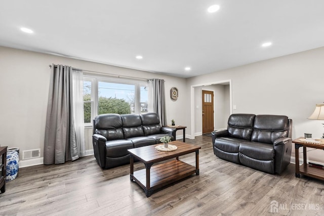 living area with visible vents, recessed lighting, and wood finished floors