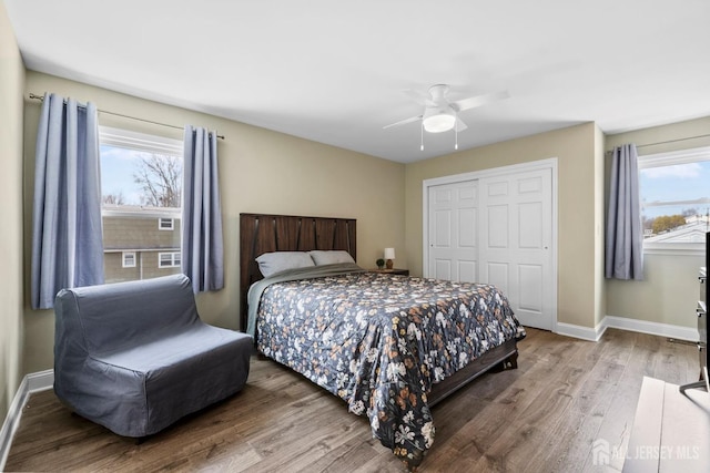 bedroom featuring ceiling fan, a closet, baseboards, and wood finished floors